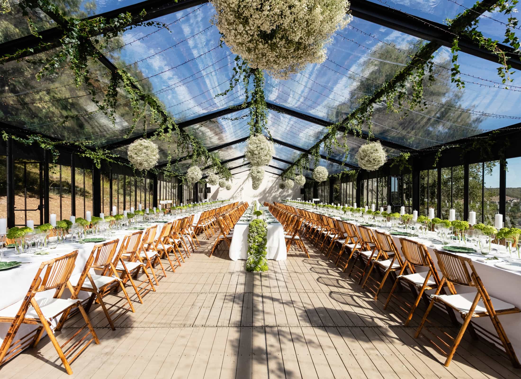 Inspiration image: long banquet tables and floral chandeliers under a tent canopy
