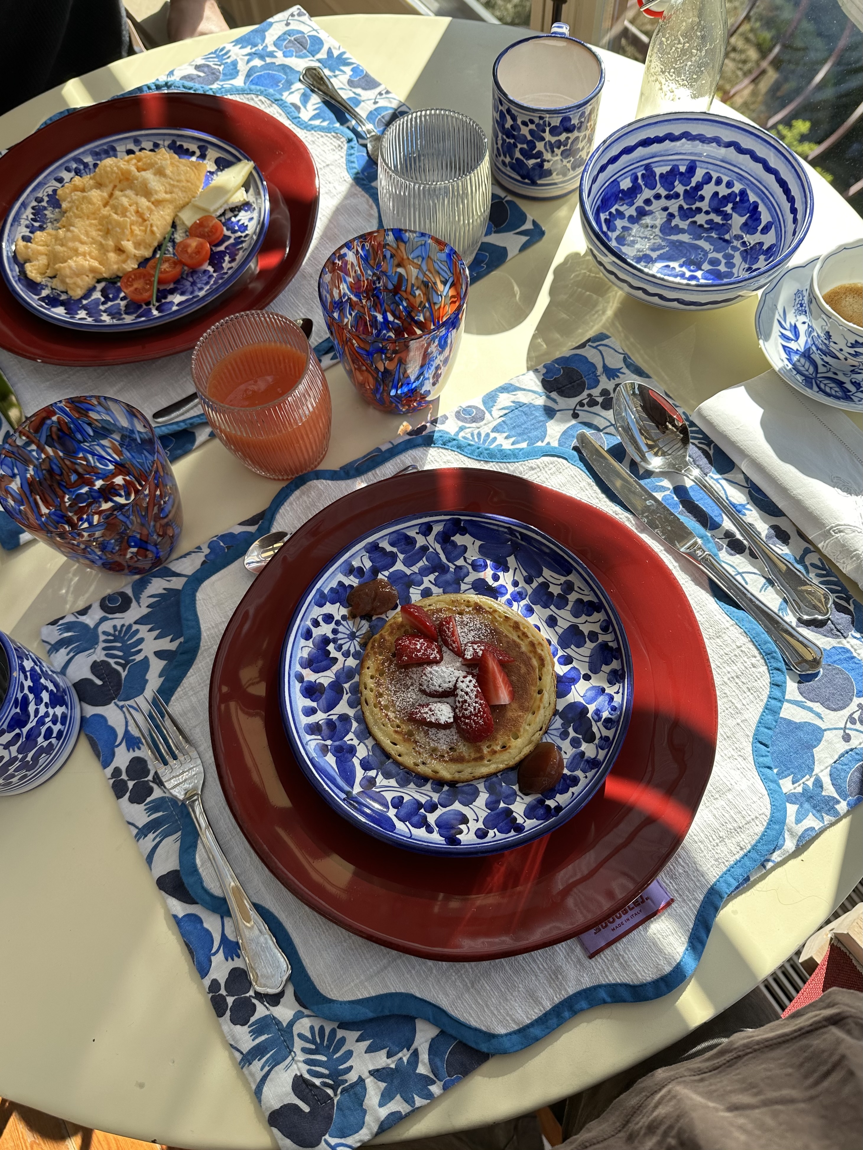 Pancakes and scrambled eggs on colourful ceramics
